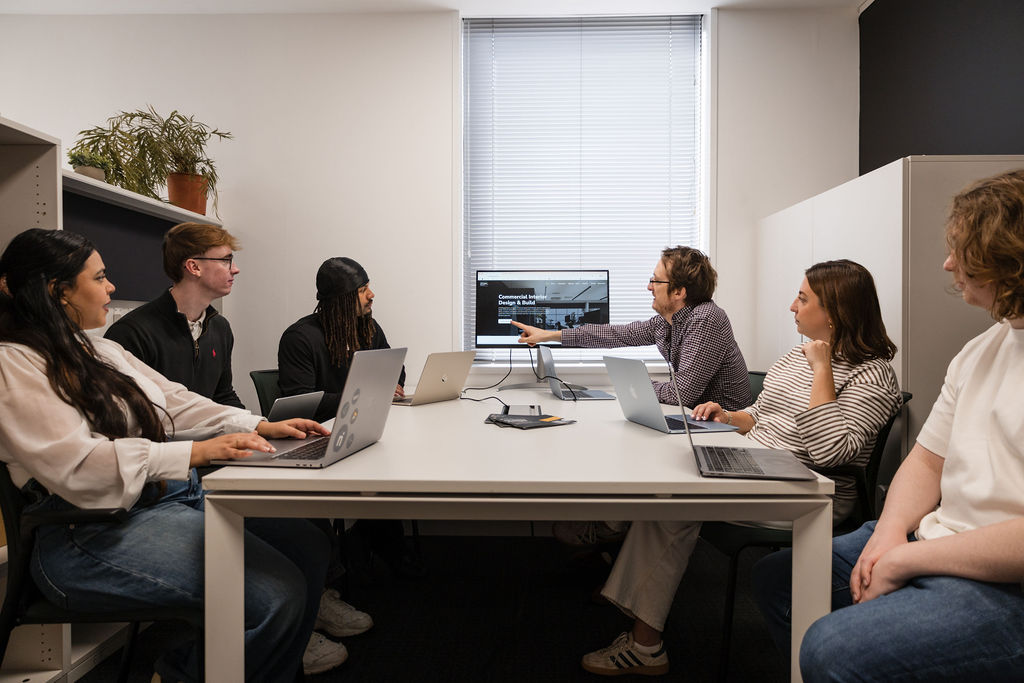 team of digital marketing experts sitting on a conference table discussing marketing data 